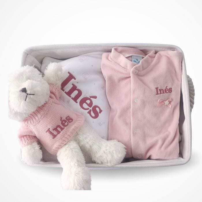 Bebé con ropa y peluche en canastilla personalizada para recién nacido.
